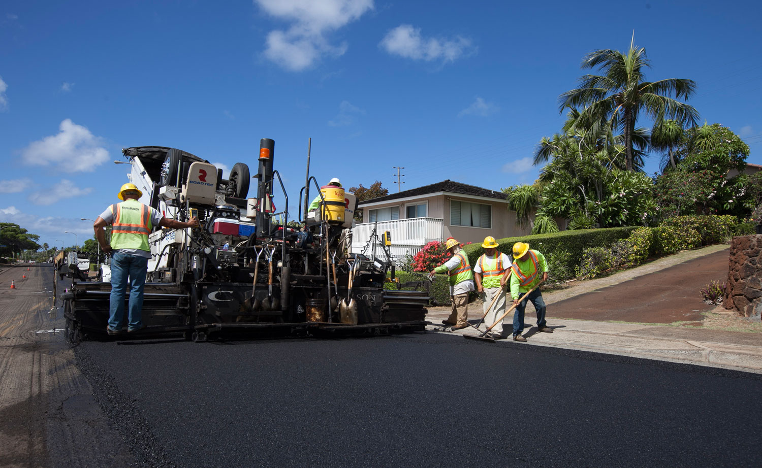 Asphalt paving crew resurfacing a residential street in Hawaii