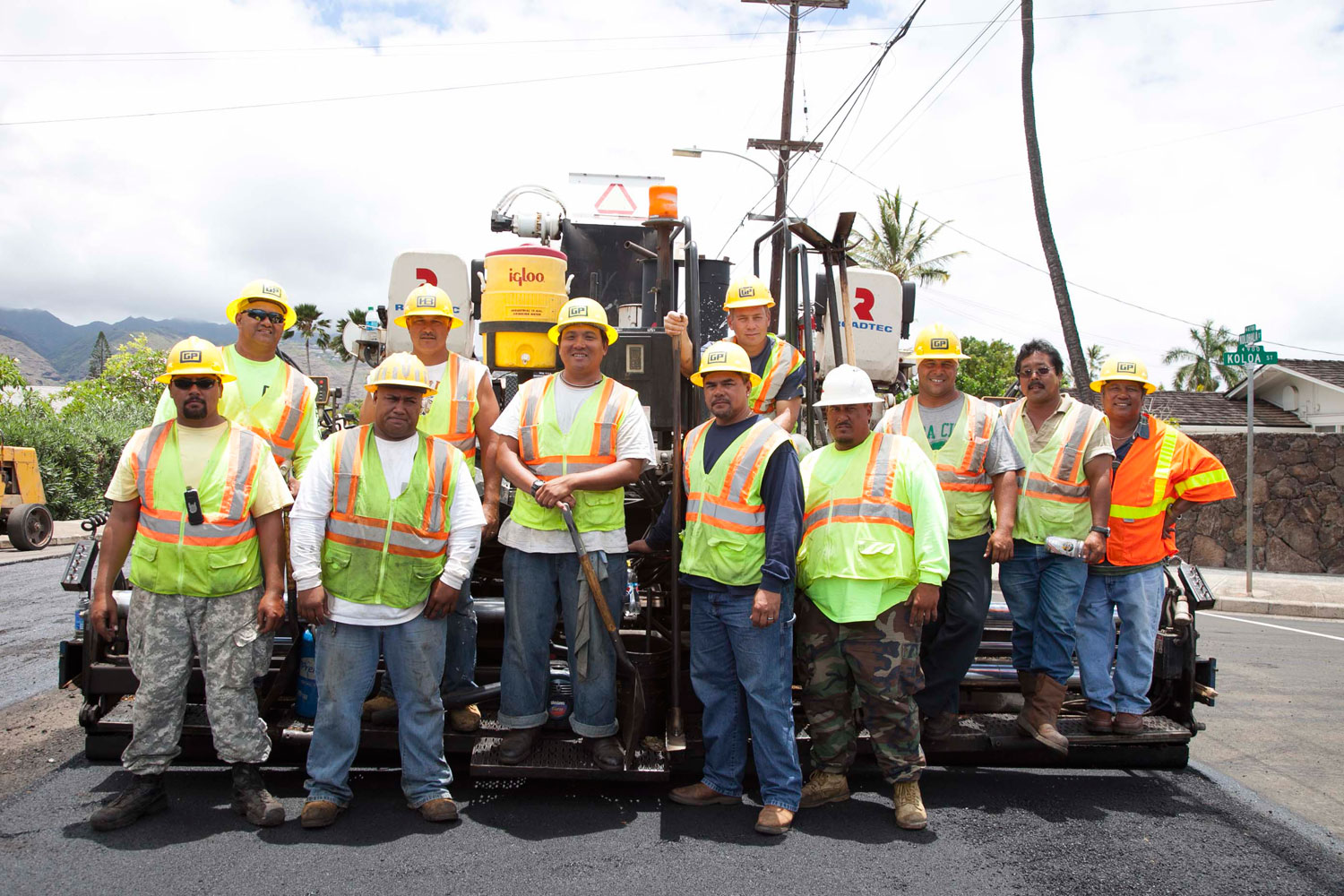 Hawaii asphalt paving crew standing in front of paving equipment