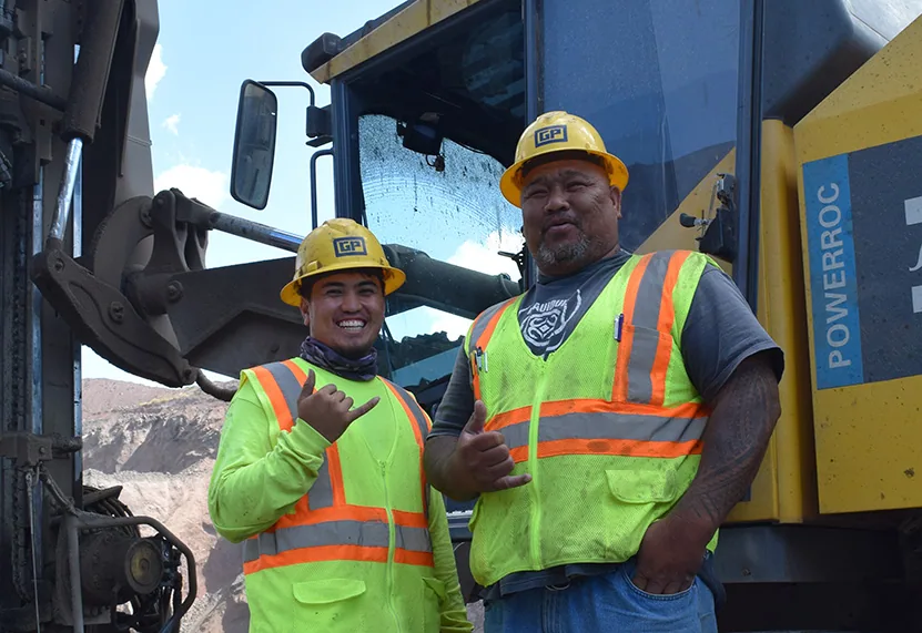 Two Grace Pacific crew members beside quarry equipment
